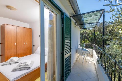 ZastražišćeにあるApartments by the sea Cove Pokrivenik, Hvar - 2073のベッドとバルコニーのある寝室