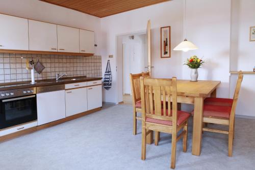 a kitchen with a wooden table and chairs in a kitchen at Ferienwohnung Zum Bäckersepp in Neuschönau