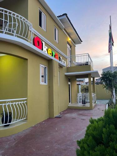 a yellow building with a balcony on top of it at Okera Inn Hotel in Accra