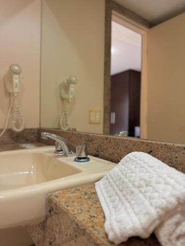 a bathroom with a sink and a mirror at Studio pé na areia, vista, internet e ar in Macaé