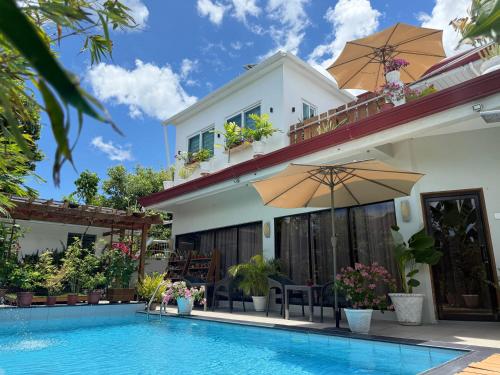 a villa with a swimming pool in front of a house at LRS Apartment in Basdiot