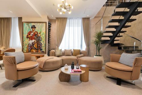 a living room with couches and chairs and a staircase at Luxury 3 bedroom penthouse with 2 living room in Lekki