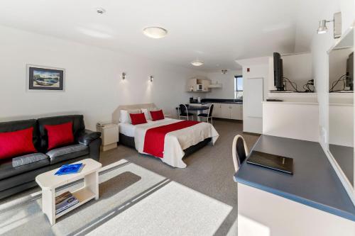 a hotel room with a bed and a couch at Avalon Manor Motel in Motueka