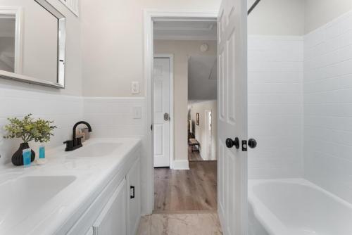 een witte badkamer met 2 wastafels en een bad bij Luxury 4BR Pool Jacuzzi Arcade USC Ft Jackson in Columbia