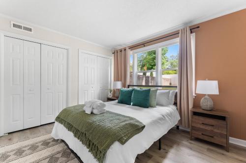 een slaapkamer met een groot bed en een raam bij Luxury 4BR Pool Jacuzzi Arcade USC Ft Jackson in Columbia