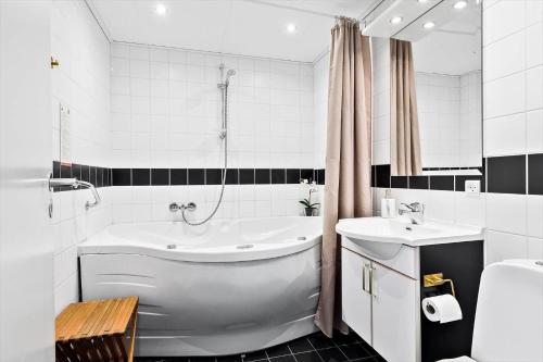 une salle de bain blanche avec une baignoire et un lavabo dans l'établissement TV1274-Bindslev-Tannisbugtvej-49-D-Nr-10, à Bindslev