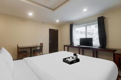 a bedroom with a white bed and a window at Townhouse DJ Grand in Tirupati