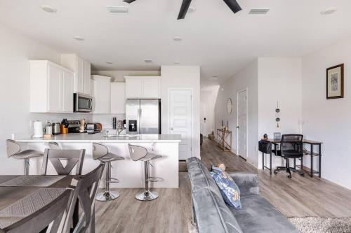 a kitchen and living room with white cabinets and a couch at Turnkey Coastal Luxury Townhome EV Ready in Pensacola