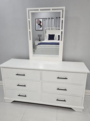 a white dresser with a mirror on top of it at The Luxe Paradise in Curatoe Hill
