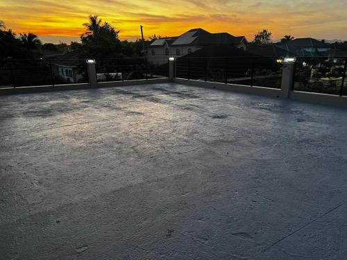 a rooftop with a sunset in the background at The Luxe Paradise in Curatoe Hill