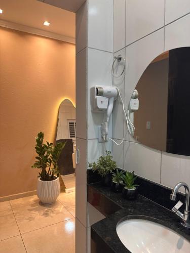 a bathroom with a sink and a mirror at Caribbei Apartamentos de Hospedagem in Maragogi