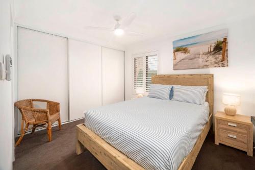 una camera da letto con un letto e una sedia di 'Bay Parklands' - Coastal Resort Experience a Nelson Bay
