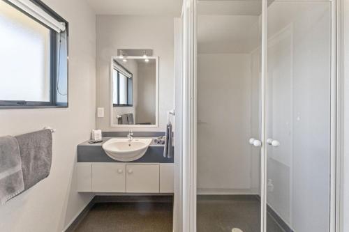 a bathroom with a sink and a shower at Avalon Manor Motel in Motueka
