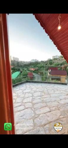 a view of a patio from a window of a building at اكوخ في مزرعة بساتين اللوز in Quai