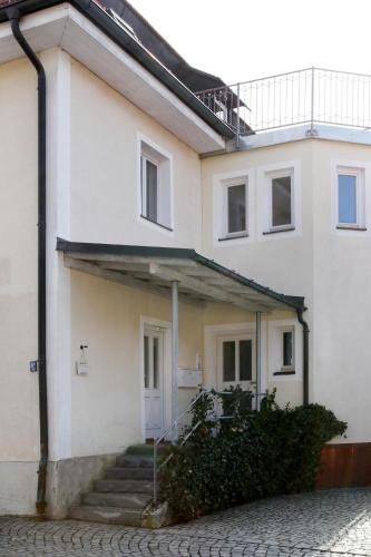 a white house with stairs in front of it at Ferienwohnung Zum Bäckersepp in Neuschönau