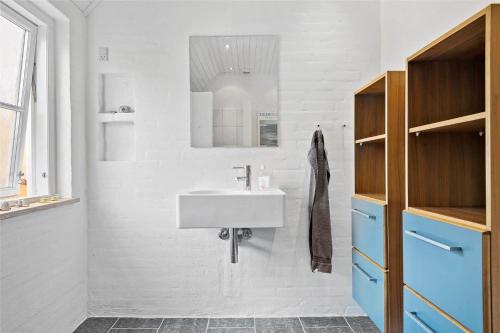 a white bathroom with a sink and a mirror at TV1405-Skagen-Skomagergangen-5 in Skagen