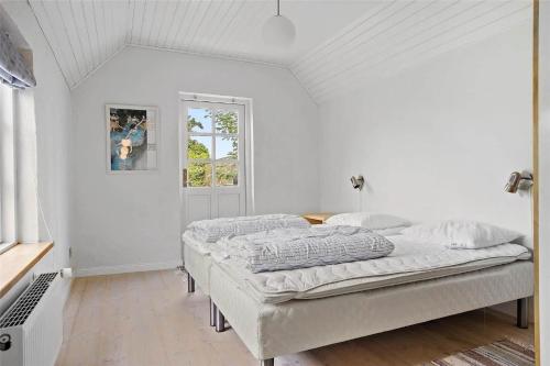 a white bedroom with two beds and a window at TV1405-Skagen-Skomagergangen-5 in Skagen