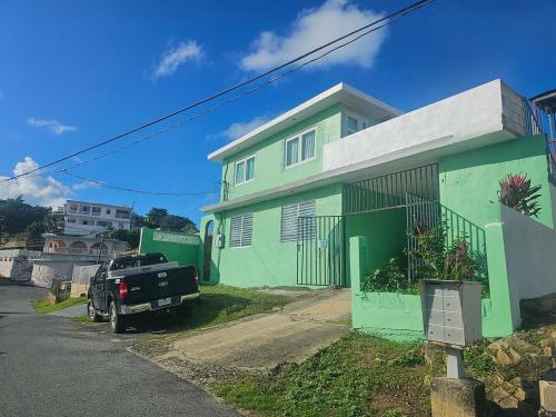 a truck parked in front of a green and white house at Casa Verde in Naguabo