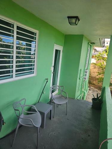two chairs and a table in a green room at Casa Verde in Naguabo