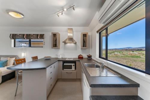 a kitchen with a sink and a large window at Avalon Manor Motel in Motueka