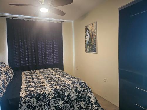 a bedroom with a bed and a black headboard at Casa Verde in Naguabo