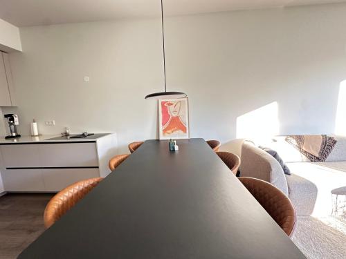 a kitchen and living room with a table and chairs at Modern and Cozy apartment in the city next to Heiðmörk, nature reserve - Birta Rentals in Garðabær
