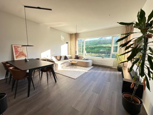 a living room with a table and a couch at Modern and Cozy apartment in the city next to Heiðmörk, nature reserve - Birta Rentals in Garðabær