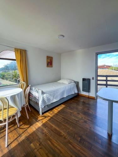 a bedroom with a bed and a table at Cabañas Las Terrazas in Pichilemu