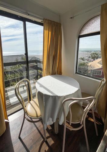 a table and chairs in a room with a window at Cabañas Las Terrazas in Pichilemu