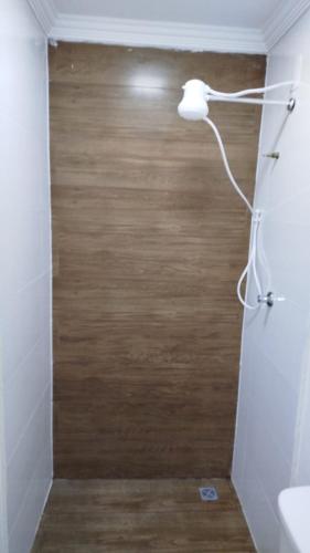 a bathroom with a shower with a wooden floor at Flats & Suítes do Lago in Guapé