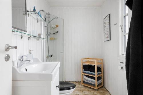 a white bathroom with a sink and a toilet at TV1638-Albaek-Orionvej-11 in Ålbæk