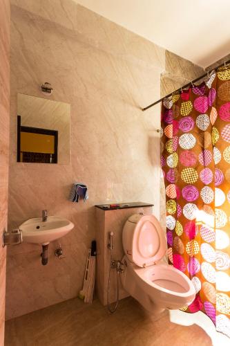 a bathroom with a pink toilet and a sink at Aneesha Bunglow in Mahabaleshwar