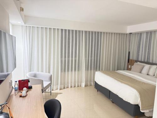 a hotel room with a bed and a desk and chair at Fabuloso Hotel das Nações - 13º Andar - Apt da Rede Premium in Brasilia