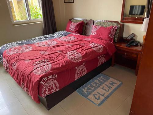 a bedroom with a large bed with a red comforter at Okera Inn Hotel in Accra