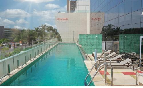a large swimming pool on the roof of a building at Fabuloso Hotel das Nações - 13º Andar - Apt da Rede Premium in Brasilia