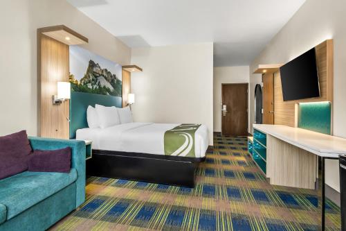 a hotel room with a bed and a couch at Quality Inn Brookings-University in Brookings
