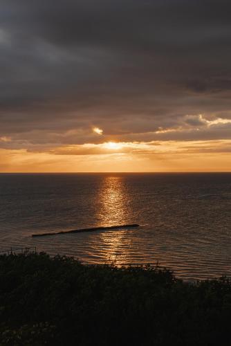 a sunset over the ocean with the sun setting at Casa Astral Hotel Boutique and Apartments in Holbox Island