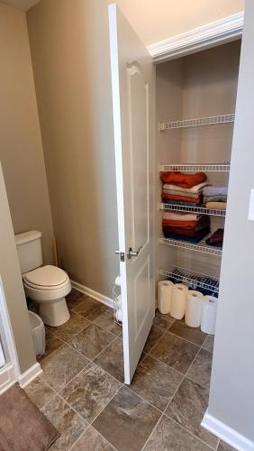 a bathroom with a toilet and a closet at Cozy SFH for Active Adults in Middletown