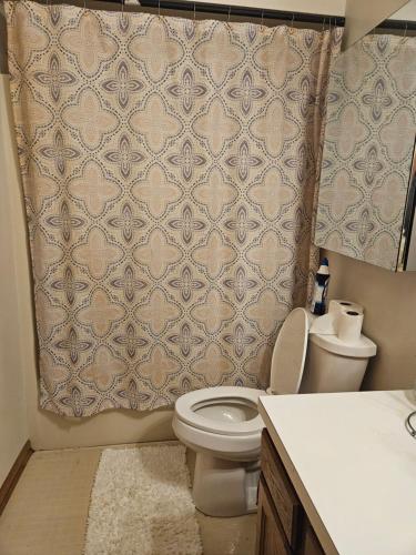 ケントウッドにあるMillhaven Villaのトイレとシャワーカーテン付きのバスルーム