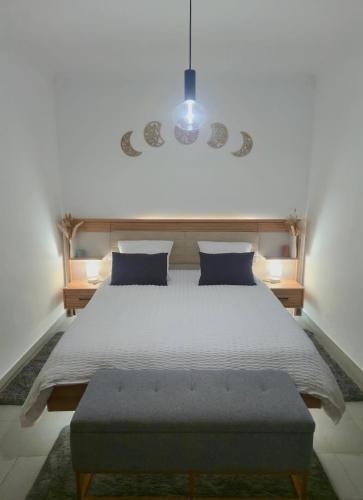 a bedroom with a large white bed with a bench at Monte do Moinho Vento in Casas Novas de Marés