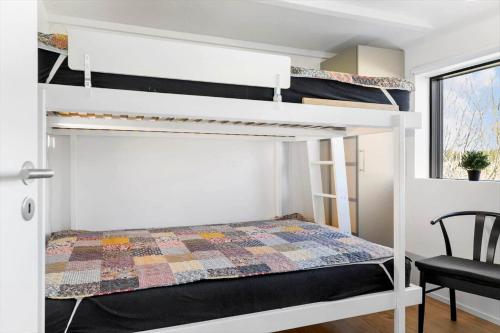 Un dormitorio con dos literas y una silla. en TV1574-Albaek-Musvagevej-105, en Ålbæk