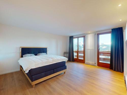 a bedroom with a large bed and wooden floors at Apartment in Les Agettes with mountain views in Agettes