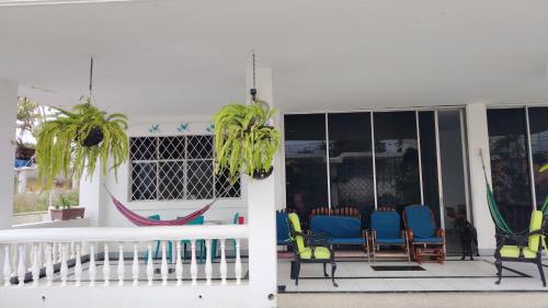 a porch with chairs and hammocks on it at Caracola, habitación privada de Flor de Lis Beach House in Playas