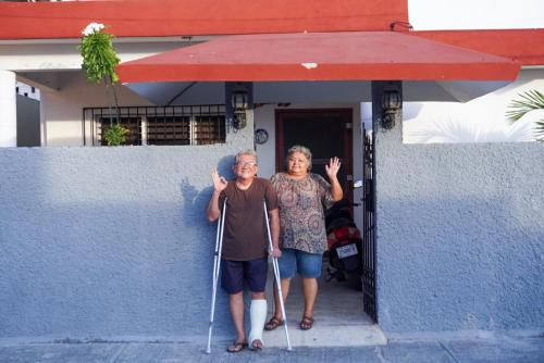 an older man and woman standing in front of a building at Casa Elena in Cozumel