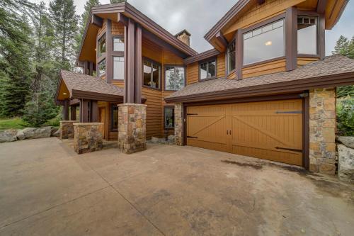 a house with a garage and a driveway at Bear Discovery Custom Tamarack Estate Home by Casago McCall - Donerightmanagement in Donnelly