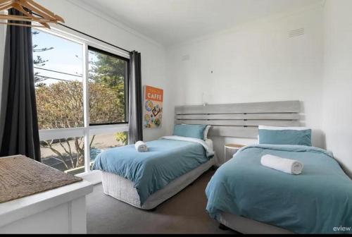 a bedroom with two beds and a large window at Water views in Cowes