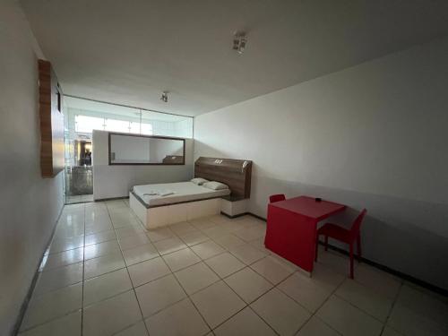 a room with a bed and a red table at Park Motel in Pará de Minas