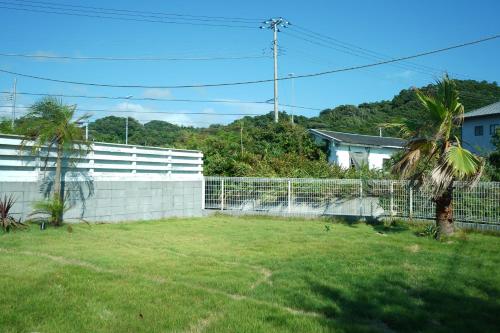 a backyard with a white fence and a palm tree at COCO VILLA 南房総 Dog Stay in Minamiboso
