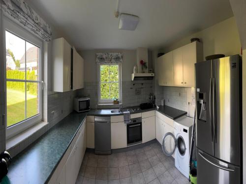 a large kitchen with white appliances and a window at Holiday Home in Robertville with Sauna & Garden in Robertville