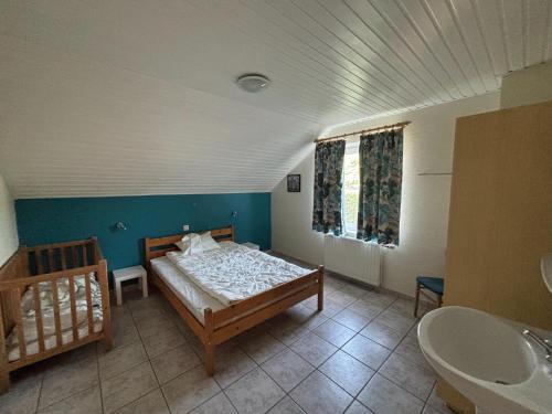 a bedroom with a bed and a bathroom with a sink at Holiday Home in Robertville with Sauna & Garden in Robertville